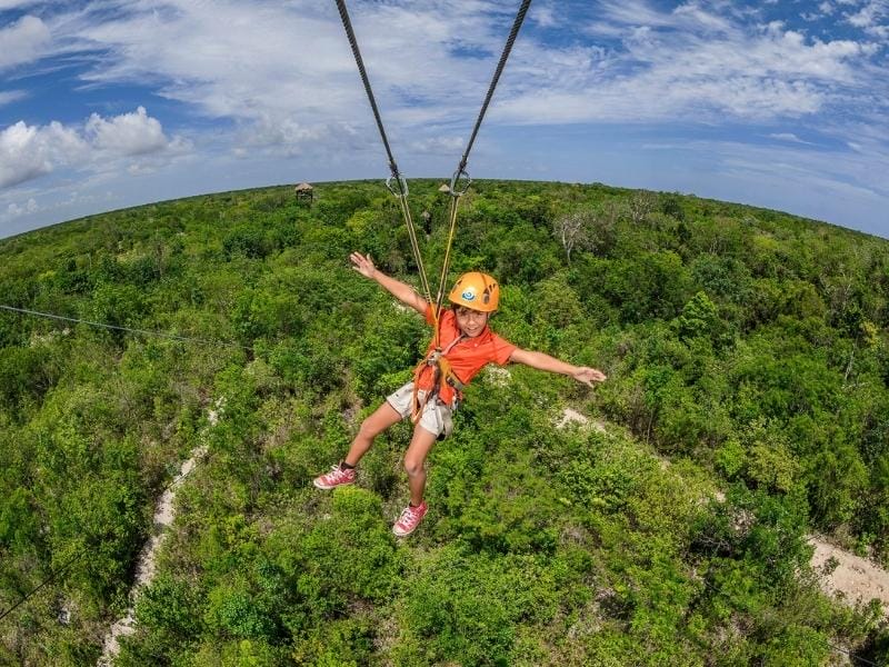 Boy on a zipline in Mexico - cenote tours Tulum