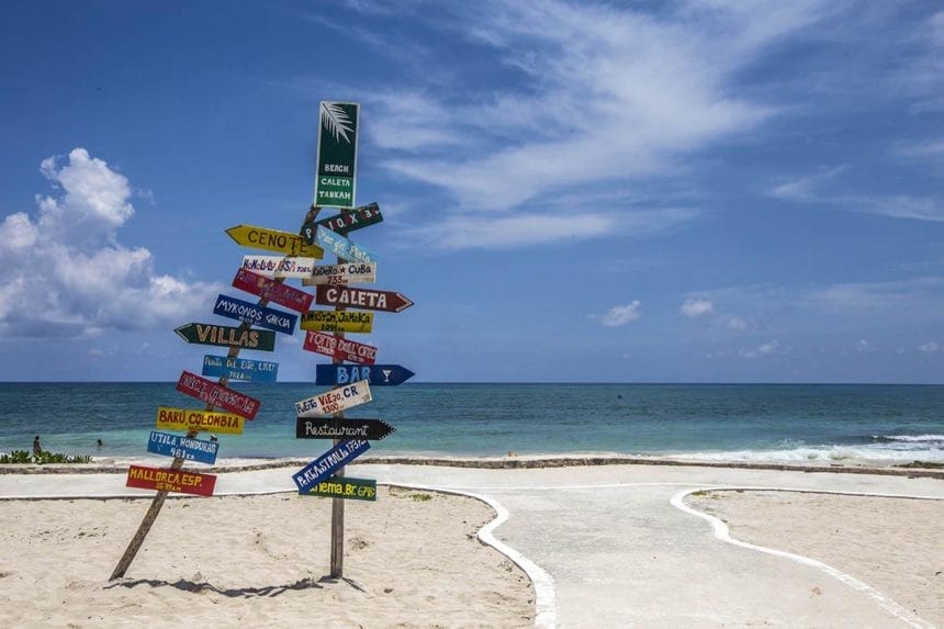 riviera maya beaches  - sign post on a white sand beach and sea in the back